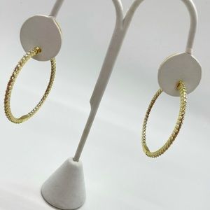 Women’s gold diamond studded hoop earrings.